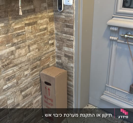 קופסה ליד דלת כניסה עם אריחי קיר
